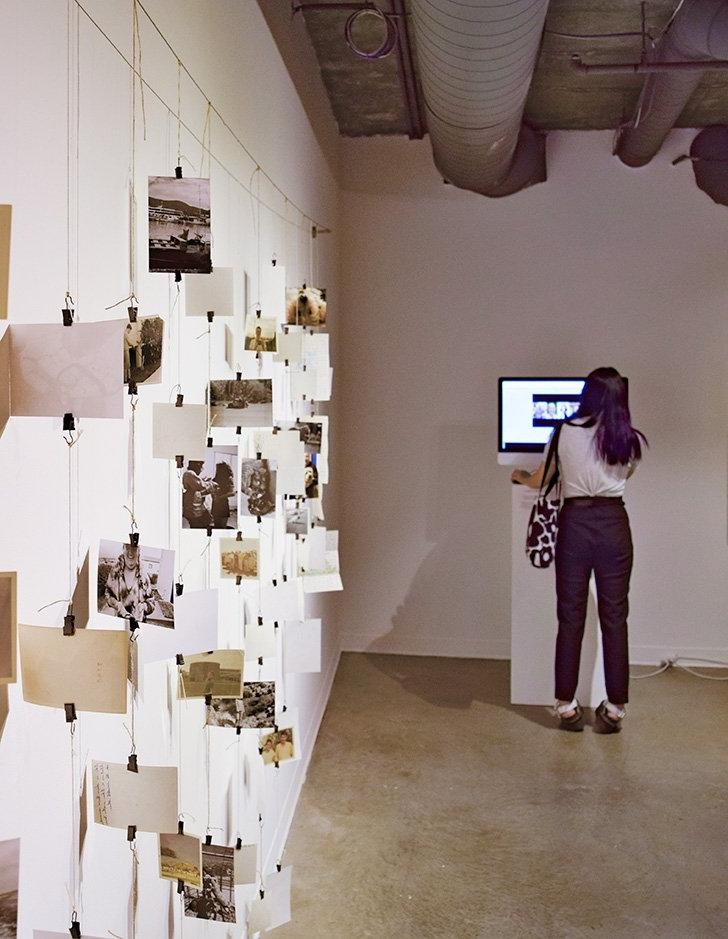 a student looks at a television screen that is part of a media studies screening exhibit. 